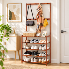 Brown bamboo coat and shoe rack in an entryway with sneakers on the shelves and a crossbody bag and scarf on the hooks