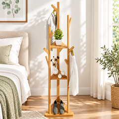 Bamboo tree coat rack in a bedroom with jackets on the hooks, a plant and vases on the shelves and shoes on the base