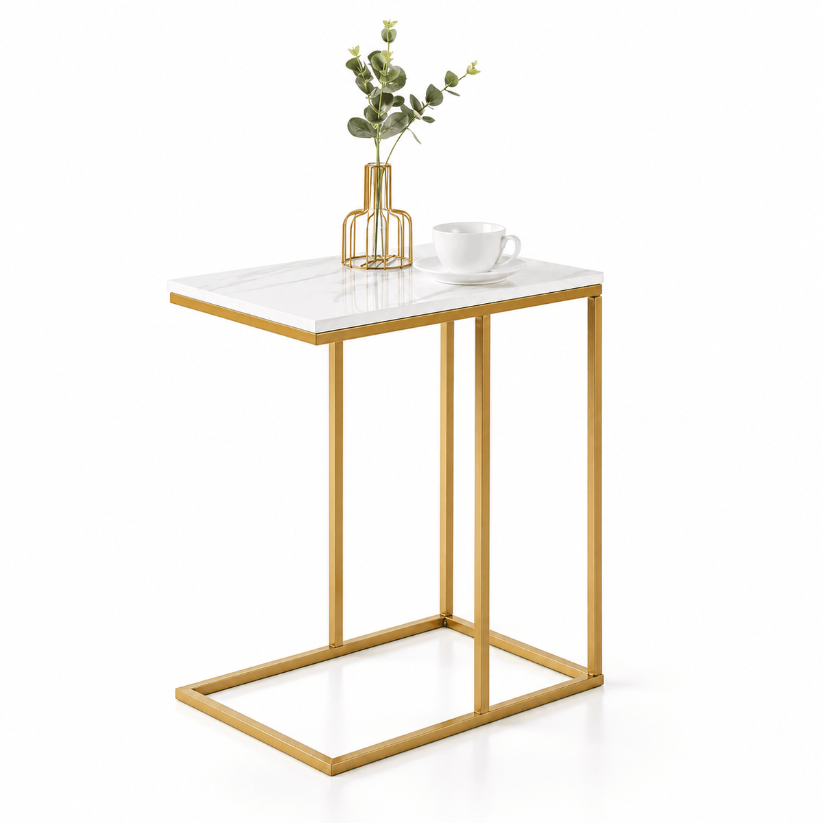 C shaped side table with a white marble look top and gold frame holding a gold vase with eucalyptus and a white tea cup