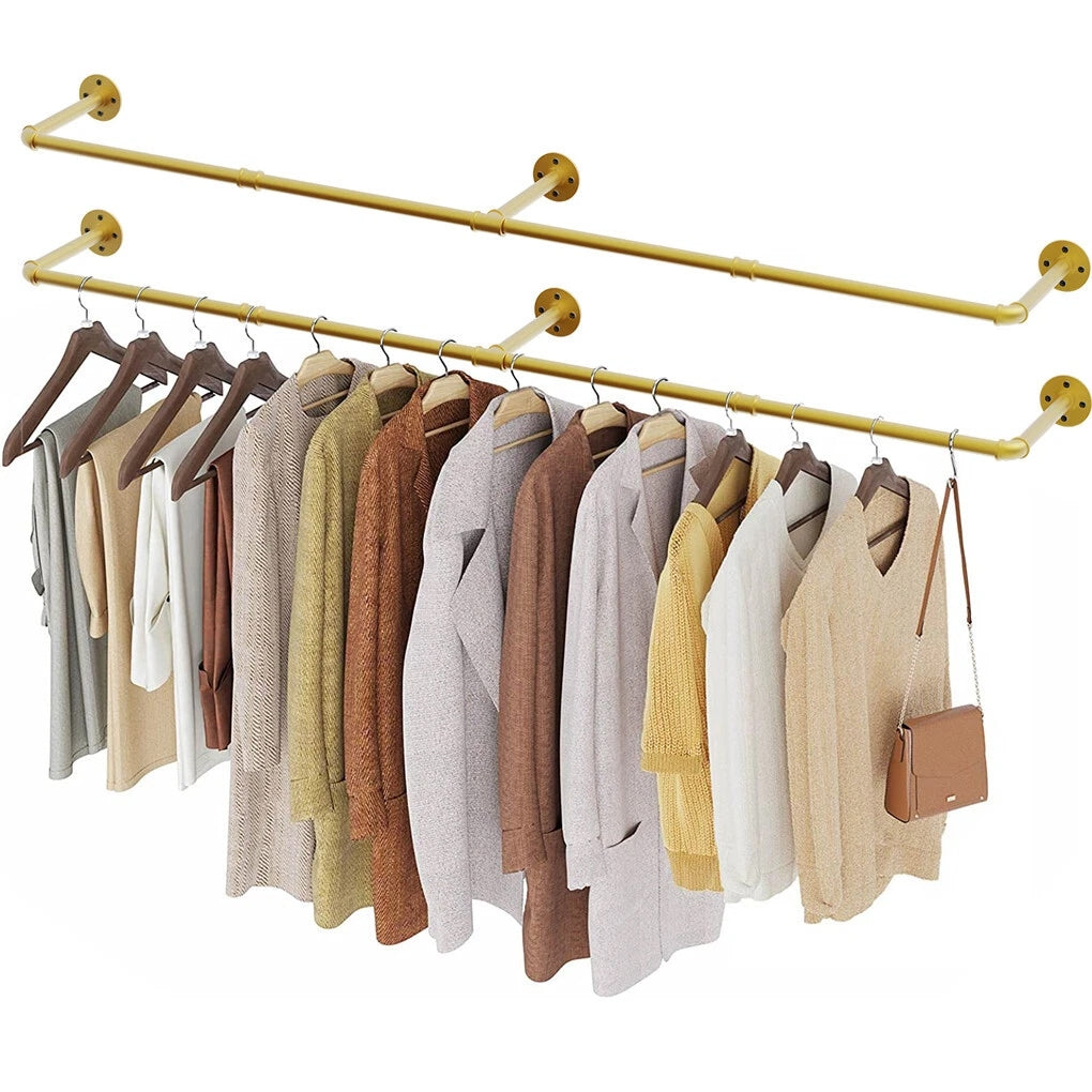 Two gold wall mounted pipe clothes racks, one empty and one holding coats, sweaters and a brown bag on hangers