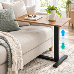 Height adjustable table with a wood look top beside a cream sofa with up and down arrows showing the height change