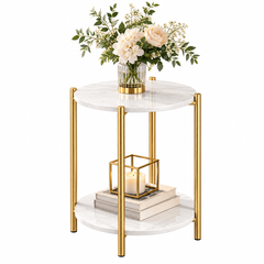 Round two tier side table with white marble look tops and four gold legs holding a vase of flowers, a candle and books